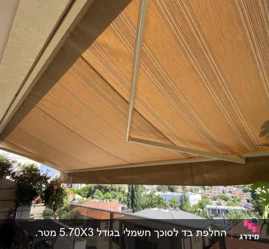 סוכך חום נפרש מעל מרפסת עם נוף עירוני